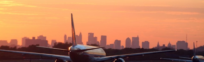 airplane before New York skyline, at departure, at sunset